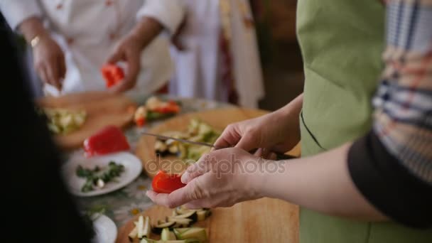 Les gens coupant du poivron rouge en master class 