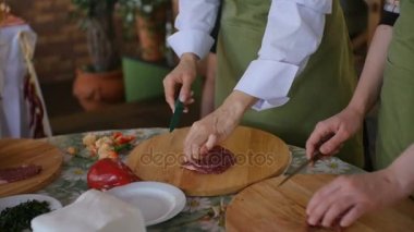 Birden çok kişi dilim çiğ et üzerinde ahşap tahta