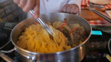 Şef Aşçı sebze, makarna ve et tavada kızartma