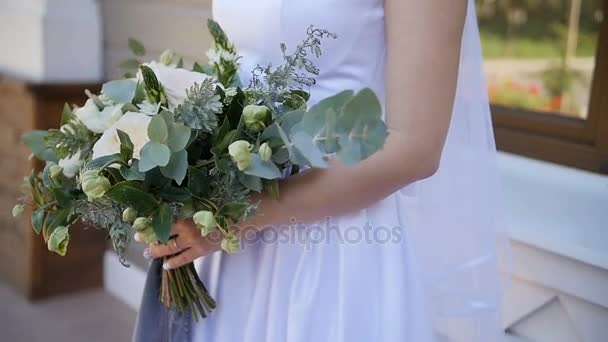 Bride in lace dress holding beautiful white and green wedding flowers bouquet, close-up — Stock Video
