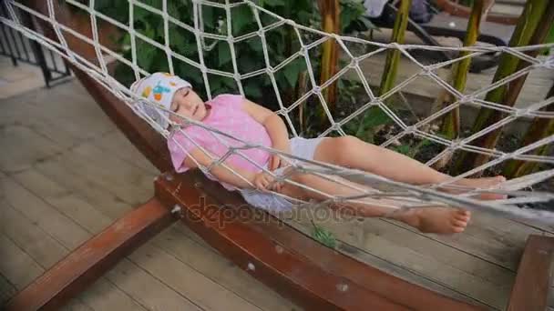 Close up of a little girl in a hammock on a sunny day on a backyard — Stock Video