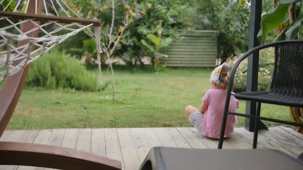 Shot of little girl sitting at the backyard — Stock Video