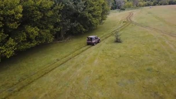 Antenne. über dem Geländewagen fliegen, der schnell im Gelände durch ländliche Gegenden fährt — Stockvideo