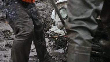 Adam koca Yükaldırma jack ağır çekimde off-road aracı kaldırmak için kullanır. Çamur ve toprak şaşırıp kalmış araba almaya çalışın.