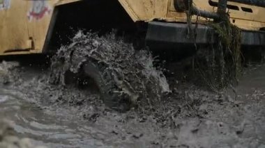 Bir araba tekerleği Close-Up kirli su ve çamur içinde sıkışmış. Tekerlek çaresiz bu dönüyor