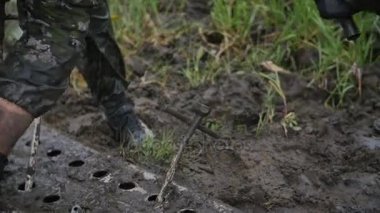 Adam strike büyük çivi çekiç yavaş hareket ile. Çamur ve toprak şaşırıp kalmış araba almaya çalışın.