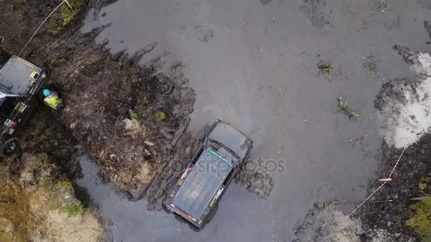 Aerial 4K. Top down view of off-road cars stuck in the mud and try to get out — Stock Video