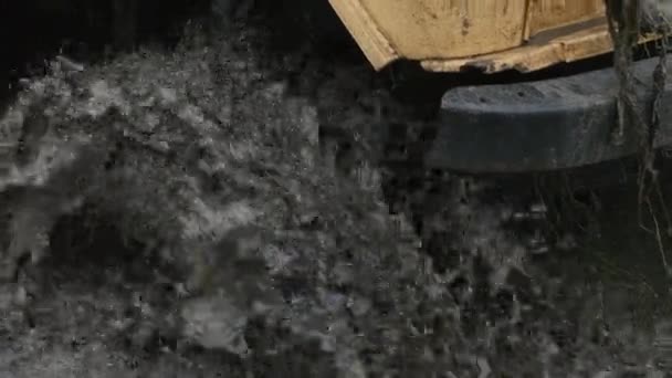 Bir araba tekerleği Close-Up kirli su ve çamur içinde sıkışmış. Tekerlek çaresiz bu dönüyor — Stok video