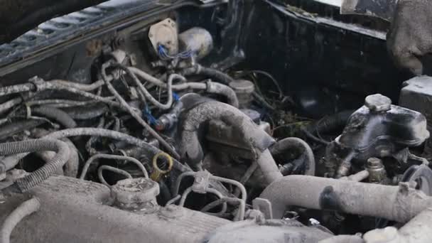 Mecánico de coches tratar de hacer la reparación rápida del coche con hacha al aire libre. Todo está sucio. . — Vídeos de Stock