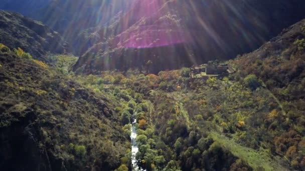 Drone aéreo tiro de ravibe floresta entre montanhas com rio e mosteiro abandonado abaixo — Vídeo de Stock