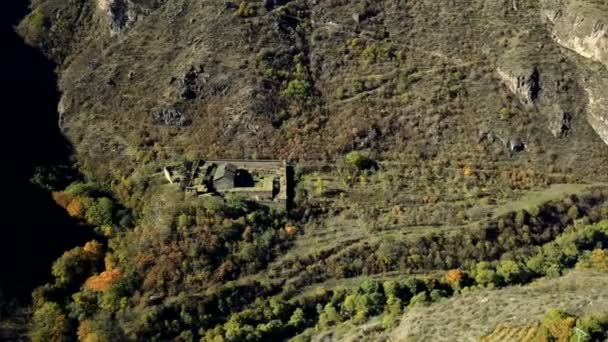 Drone aéreo tiro de ravibe floresta entre montanhas com rio e mosteiro abandonado abaixo — Vídeo de Stock