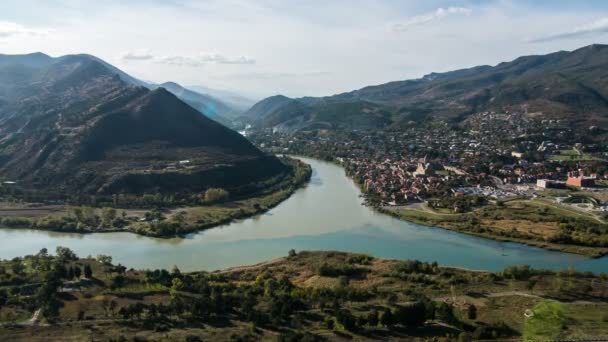 Timelapse 4K. Vue depuis le monastère de Jvari sur la ville de Mtskheta et la confluence des rivières Aragvi et Kura. Après-midi, ciel bleu, nuages, montagnes . — Video