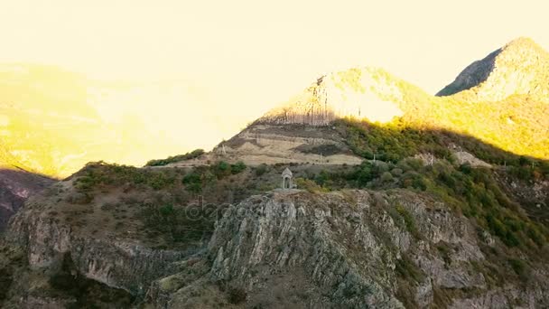 Une petite chapelle sur le bord de la montagne contre le matin. Plan aérien — Video