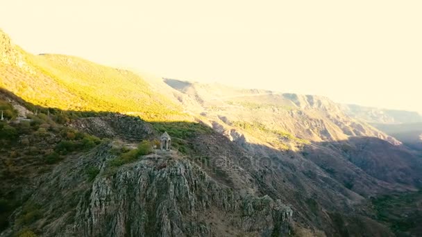 A small chapel on the mountain edge against at the morning. Aerial shot — Stock Video