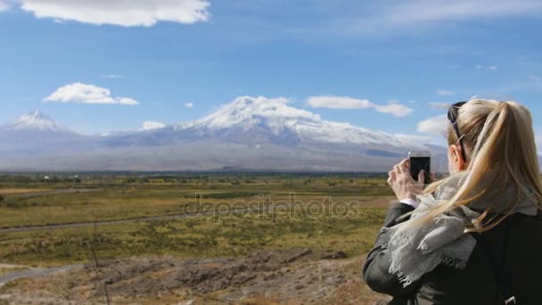 Vacanza donna di viaggio scattare foto di paesaggio montano Ararat. Natura durante le vacanze estive. Giovane femmina in piedi di vedetta e fare colpi sul suo telefono cellulare . — Video Stock