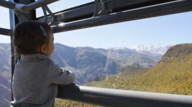 Küçük turist kız sürme teleferik en uzun teleferik kabinde Tatev kanatları içinde