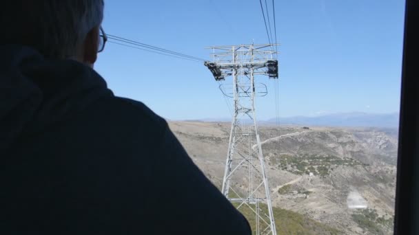 Toeristische Man rijden in de kabelbaan in de langste kabelbaan cabine vleugels van Tatev — Stockvideo