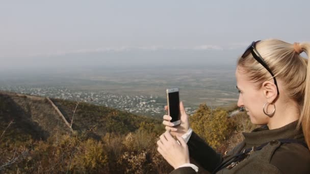 Giovane donna utilizza uno smartphone per video una bella vista sulle montagne — Video Stock