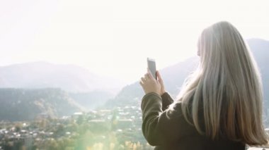 Kız çekici fotoğraf peyzaj cityscape dan dağ üst üzerinde akıllı telefon, kadın turist ayakta üzerinde Cliff zevk sabah