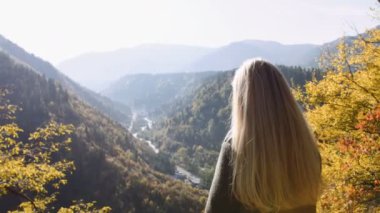 Arkadan görünüşü cliff üzerinde duran, nefes kesici gündoğumu izlerken kadın erkek ve keyfini çıkarın. Güneş ışınları parlama ona ışınla, vahşi doğa Dağları doruklarına ilham zevk harika ufuk gezi