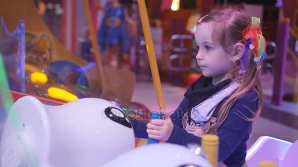 Little girl holding water gun and playing the virtual shooting game with water gun on playground in trade mall — Stock Video