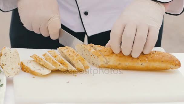 Chef mains masculines coupant du pain de blé sur la planche en bois — Video