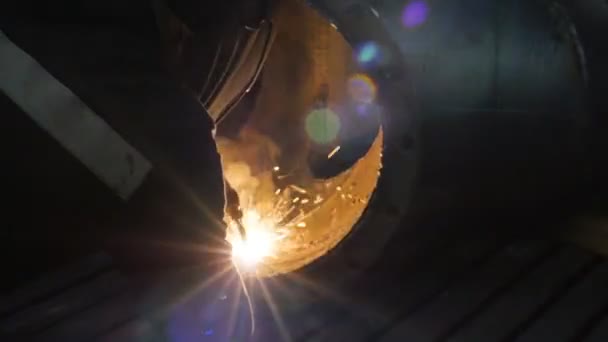 Dělník se svařovací maskou uvnitř továrny. Proces svařování části zařízení uvnitř závodu — Stock video