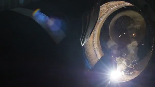 El trabajador con la máscara de soldadura dentro de la fábrica. El proceso de soldadura de una parte del equipo dentro de la fábrica — Vídeo de stock