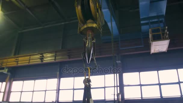 Industrial indoor crane hook on a rail. Fly around shot by steadycam — Stock Video