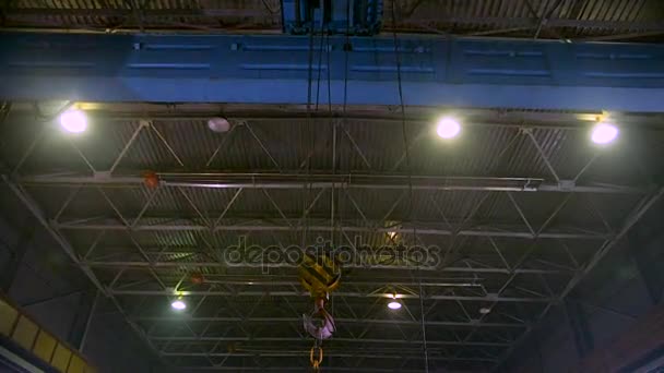Heavy bridge crane with hook moving alongside the factory — Stock Video