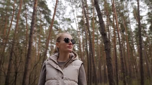 Beautiful woman in jacket waistcoat walk alone trailpath in pine forest in 4K — Stock Video