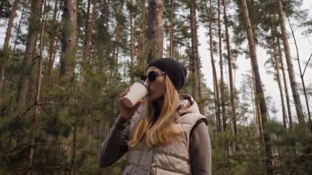 Žena pije kávu v borovém lese — Stock video