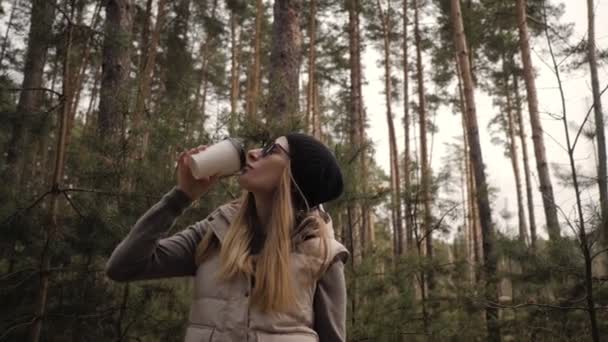 Kvinna dricka kaffe i tallskogen — Stockvideo