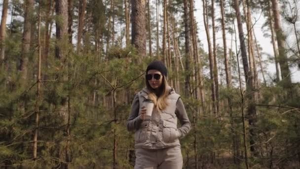 증폭기 촬영. 소나무 숲에서 커피를 마시는 여자 — 비디오