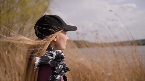 Retrato de la mujer de pie sobre el viento. Movimiento lento 4K. Clima ventoso, otoño o primavera . — Vídeo de stock