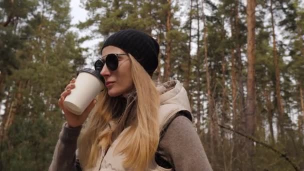 Steadycam volar alrededor de tiro. Mujer beber café en el bosque de pinos — Vídeo de stock