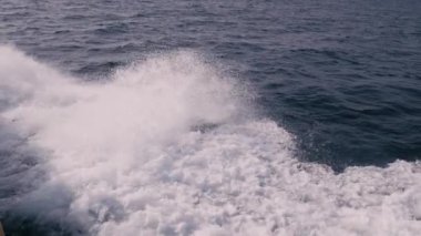Tekneden denize el salla. Ağır çekimde yan görünüm
