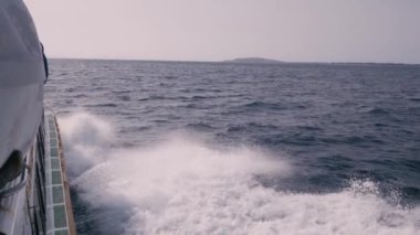 Tekneden denize el salla. Ağır çekimde yan görünüm