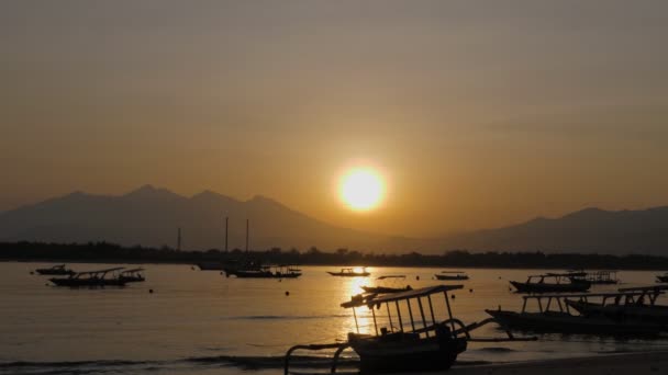 Ein Sonnenaufgang über einem Gewässer mit Fischerbooten — Stockvideo