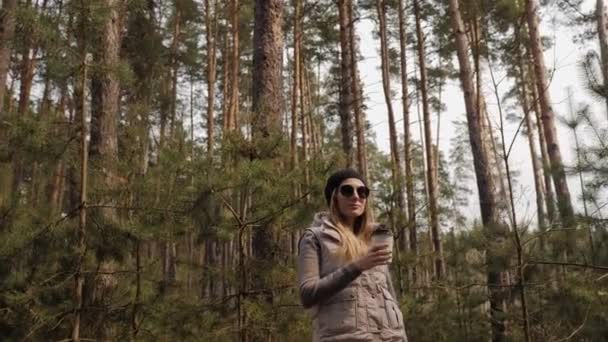 Steadycam disparó. Mujer beber café en el bosque de pinos — Vídeo de stock