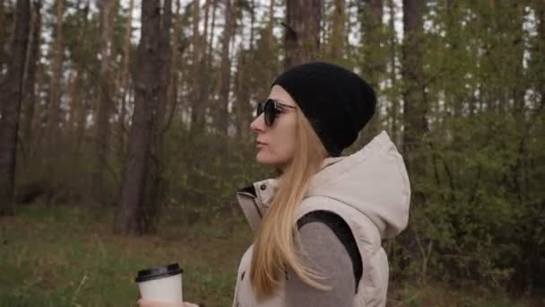 Hermosa mujer caminar en el bosque y beber café. 4K de alta calidad — Vídeo de stock