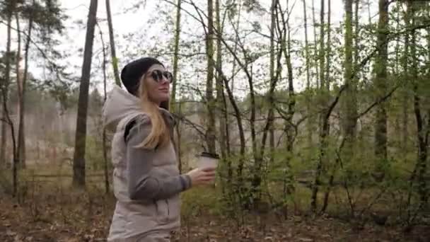 Schöne Frauen gehen im Wald spazieren und trinken Kaffee. 4K hohe Qualität — Stockvideo