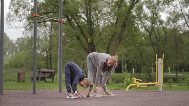 4K Moeder en dochter doen oefeningen op openlucht sport speeltuin — Stockvideo