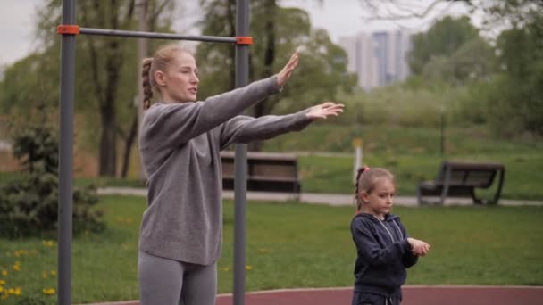 4K Moeder en dochter doen oefeningen op openlucht sport speeltuin — Stockvideo