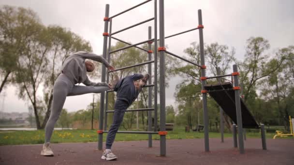4K Mère et fille faisant des exercices sur terrain de sport en plein air — Video
