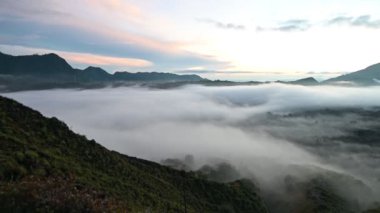Gökyüzünde bir grup bulut bir yanardağın üzerinde