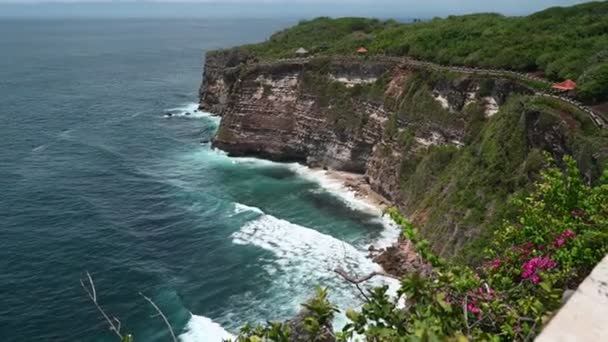 Een wankele eiland in het midden van een watermassa bij Uluwatu tempel — Stockvideo