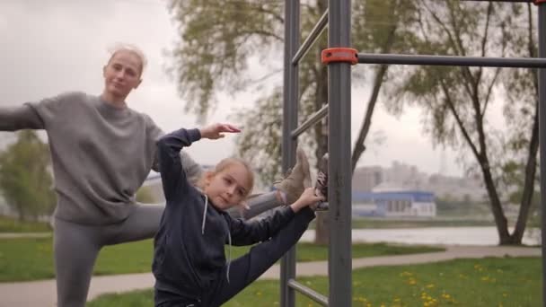 4K Moeder en dochter doen oefeningen op openlucht sport speeltuin — Stockvideo