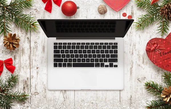 Комп'ютер ноутбуків на різдвяній сцені. Вид зверху на стіл з різдвяними прикрасами, деревом і подарунком — стокове фото