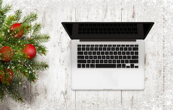 Árvore de Natal e computador portátil na mesa de madeira branca — Fotografia de Stock